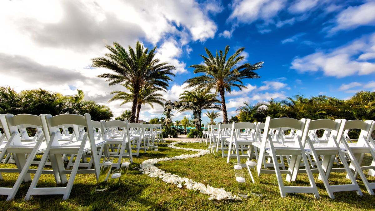 Chairs and flower petals set up for a wedding on the Margaritaville Resort Orlando event lawn.