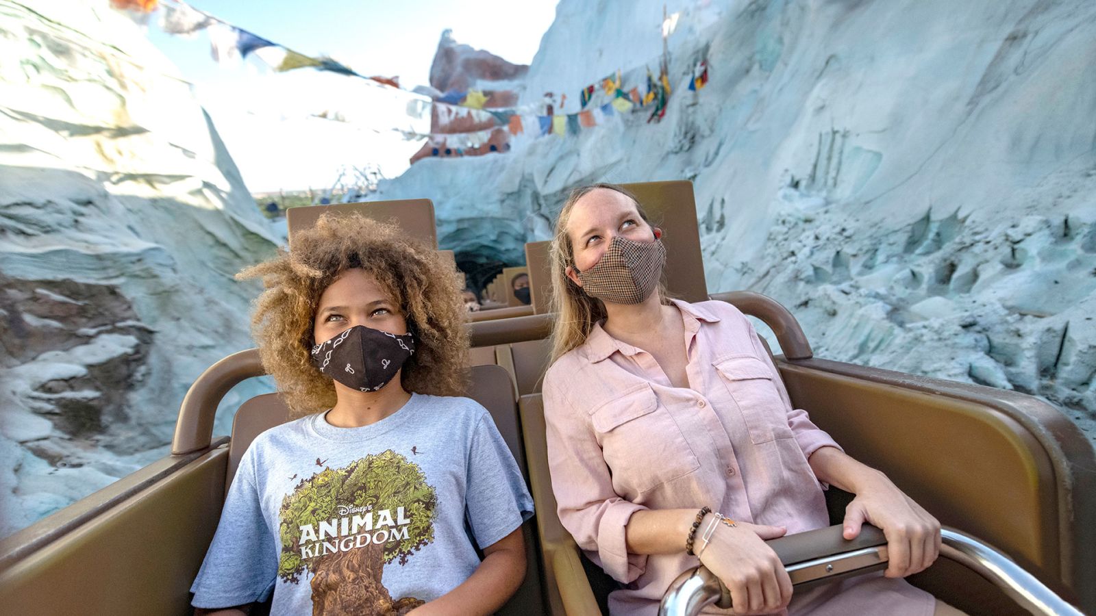 Friends in face masks riding Disney World's Expedition Everest roller coaster.