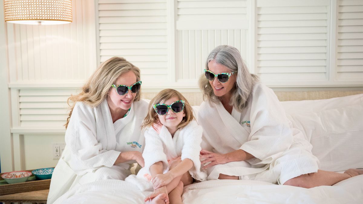 Grandmother, mother, and young daughter in Margaritaville Resort Orlando bath robes.