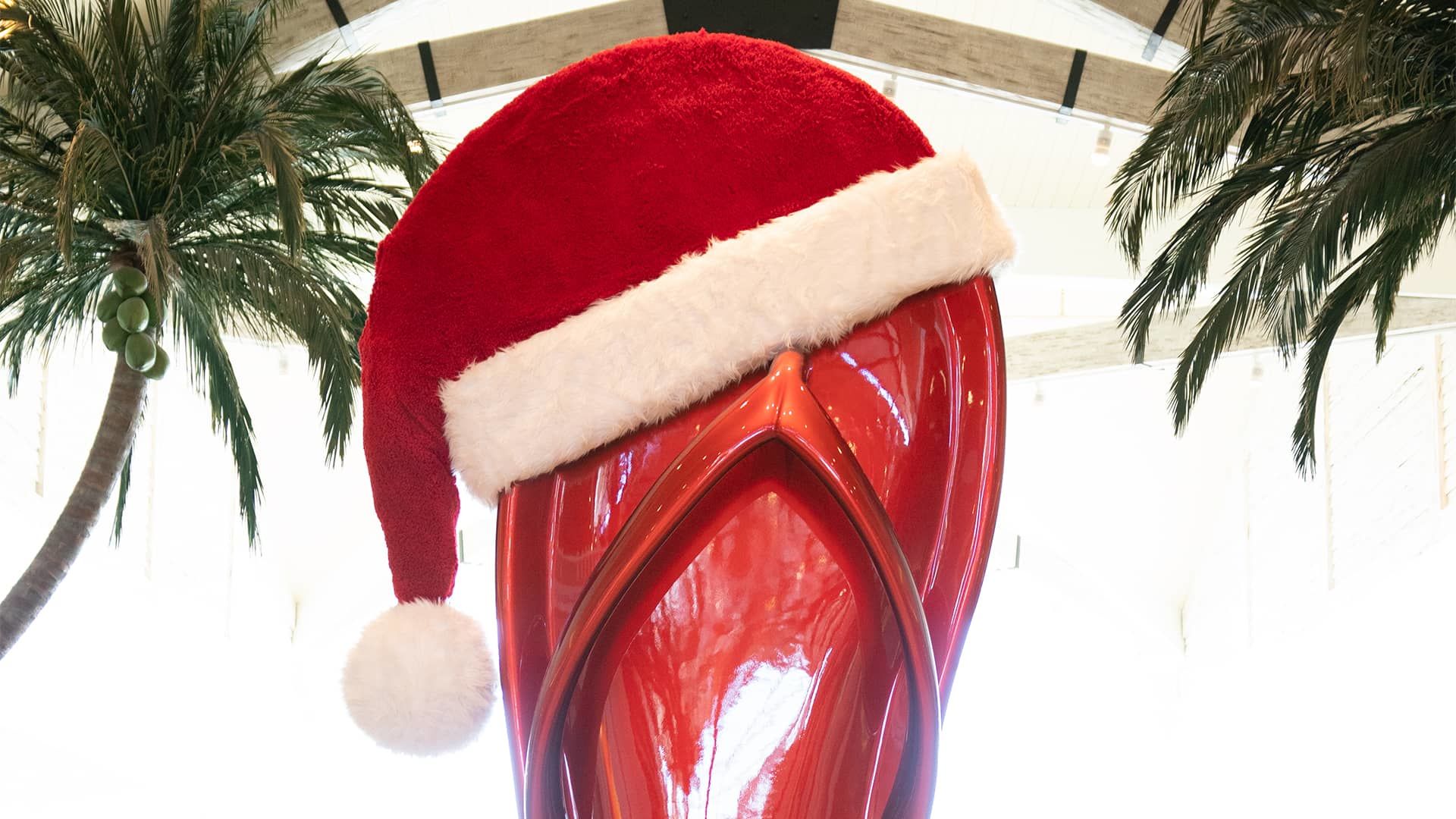 The giant Flip Flop in Margaritaville Resort Orlando’s main lobby topped with a large Santa Claus hat for the holidays.