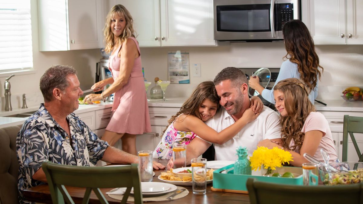 Family gathered in the kitchen of a Margaritaville Resort Orlando cottage.