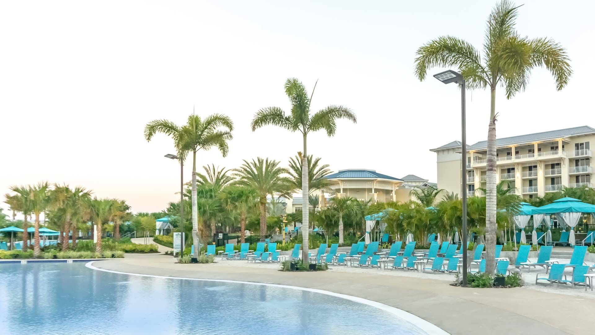 Fins Up Beach Club lined with palm trees and lounge chairs next to the Fins Up Pool at Margaritaville Resort Orlando.