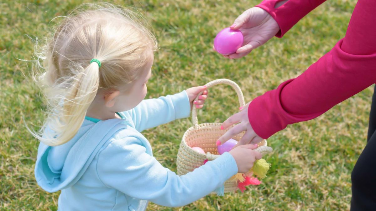 Little girl holding an basket full of Easter eggs.