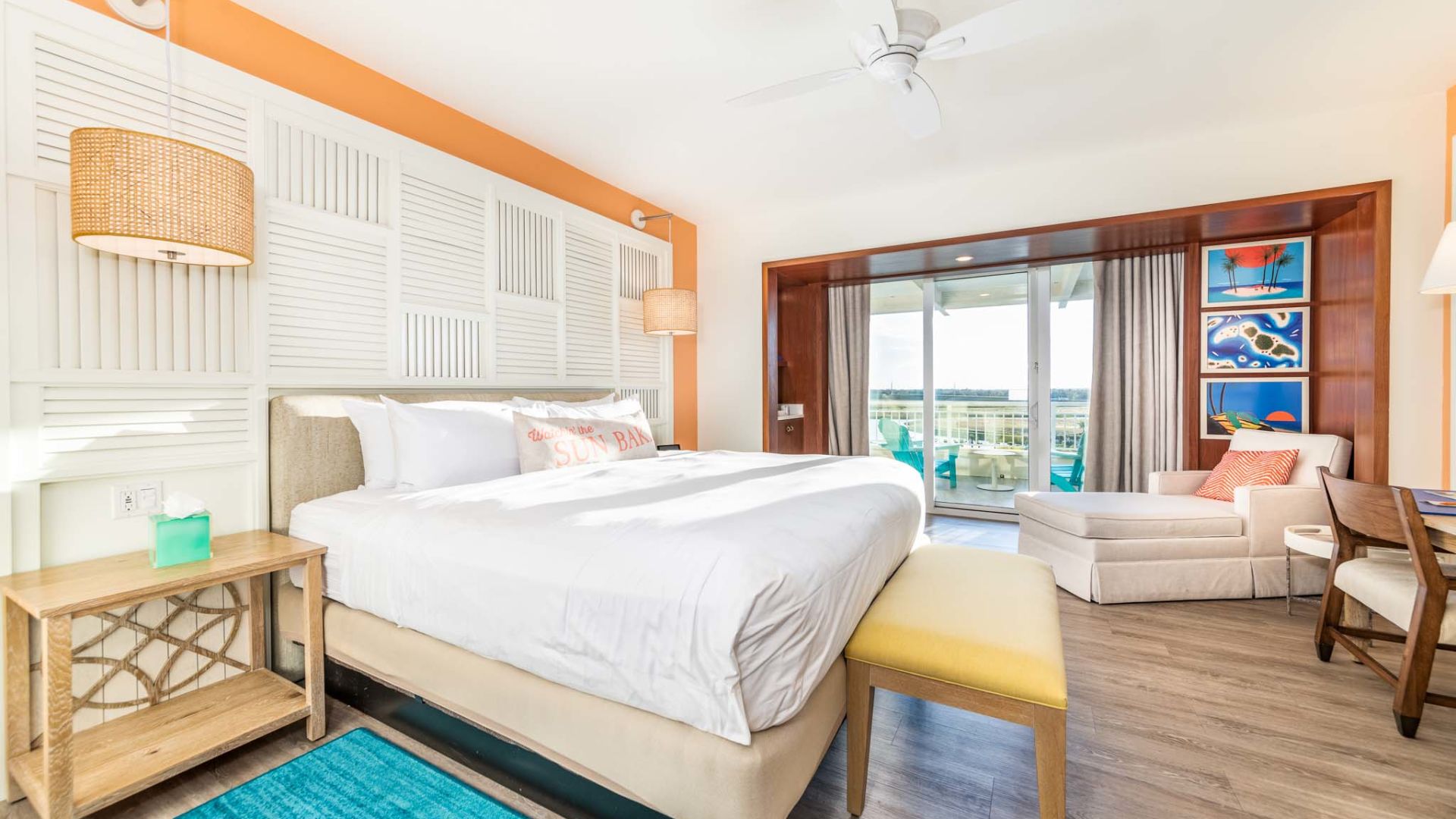 Premium king bedroom at Margaritaville Resort Orlando with large king bed, 1-seater sofa, and balcony access.
