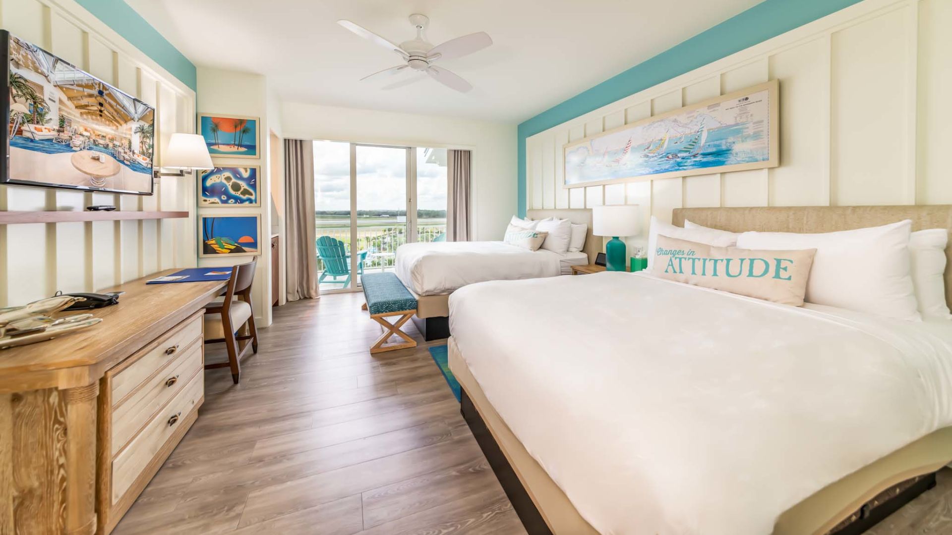 Hotel room with 2 large queen beds and a balcony overlooking the Margaritaville Resort Orlando pool area.