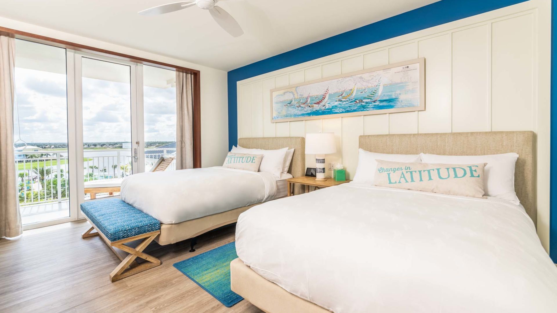 Two queen beds and door to a balcony in an accessible Margaritaville Resort Orlando suite.