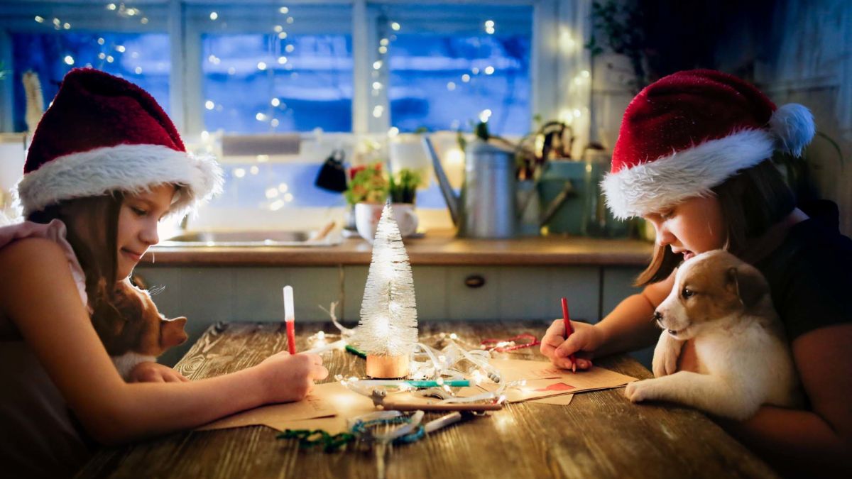 Kids with puppies writing letters to Santa Claus.