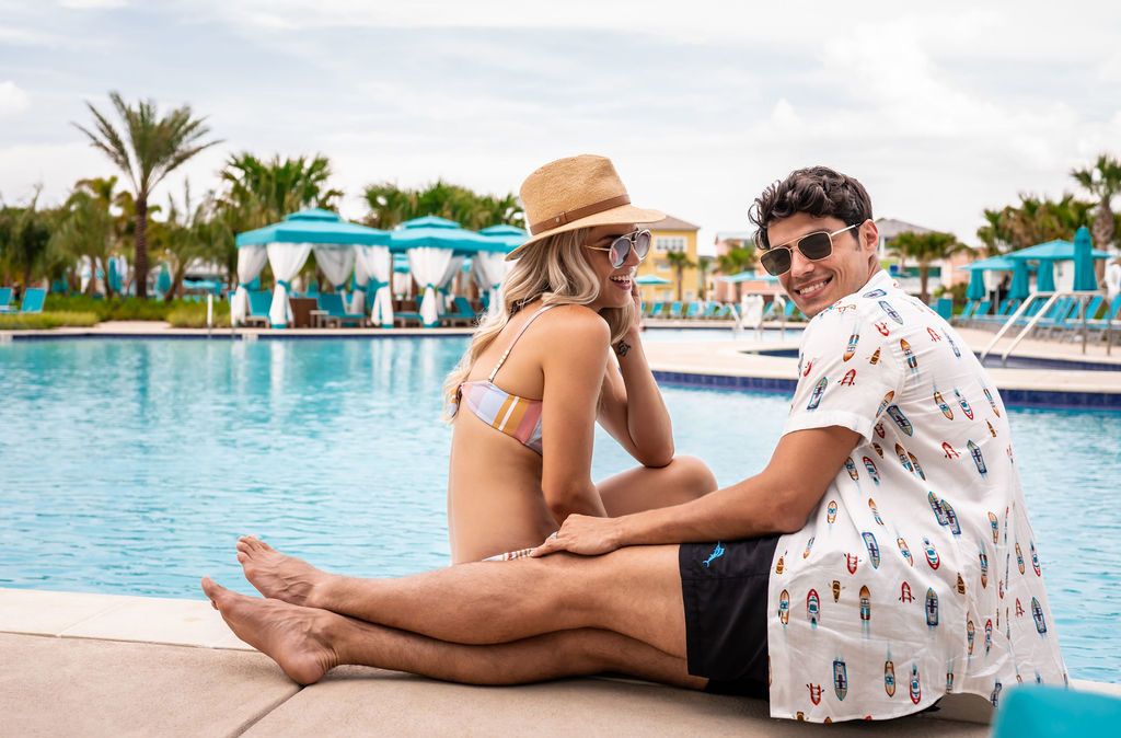 Couple sitting on edge of pool