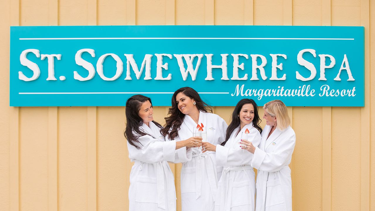 Group of friends taking a photo in front of the St. Somewhere Spa sign