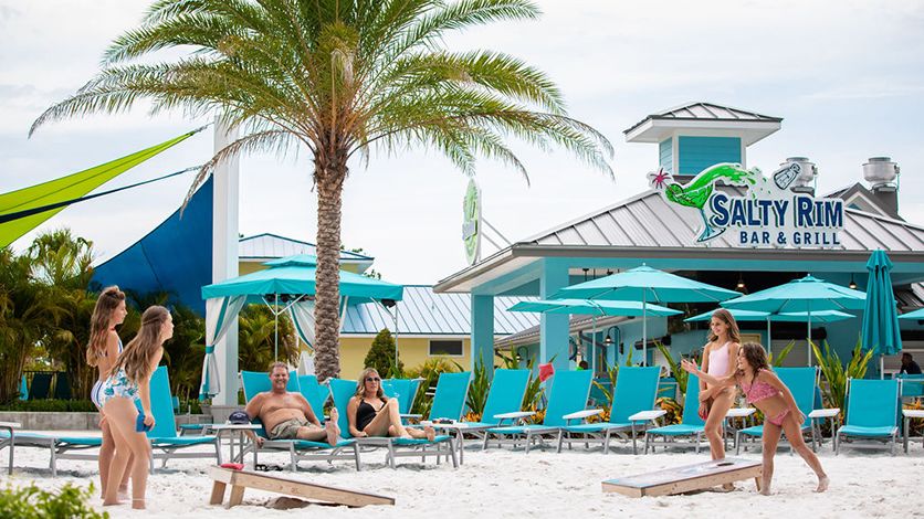 A family playing cornhole in the sand at Margaritaville Resort Orlando