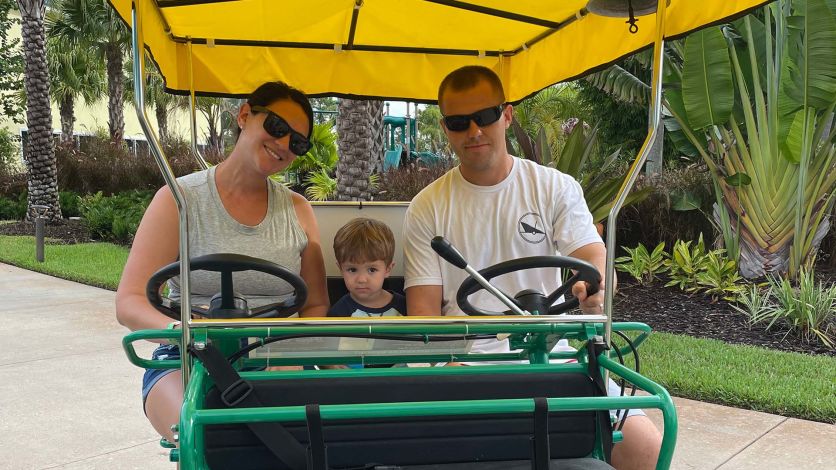 Parents and young son riding a Surrey bike at Margaritaville Resort Orlando