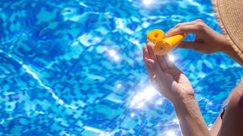 Woman applying sunscreen in a pool