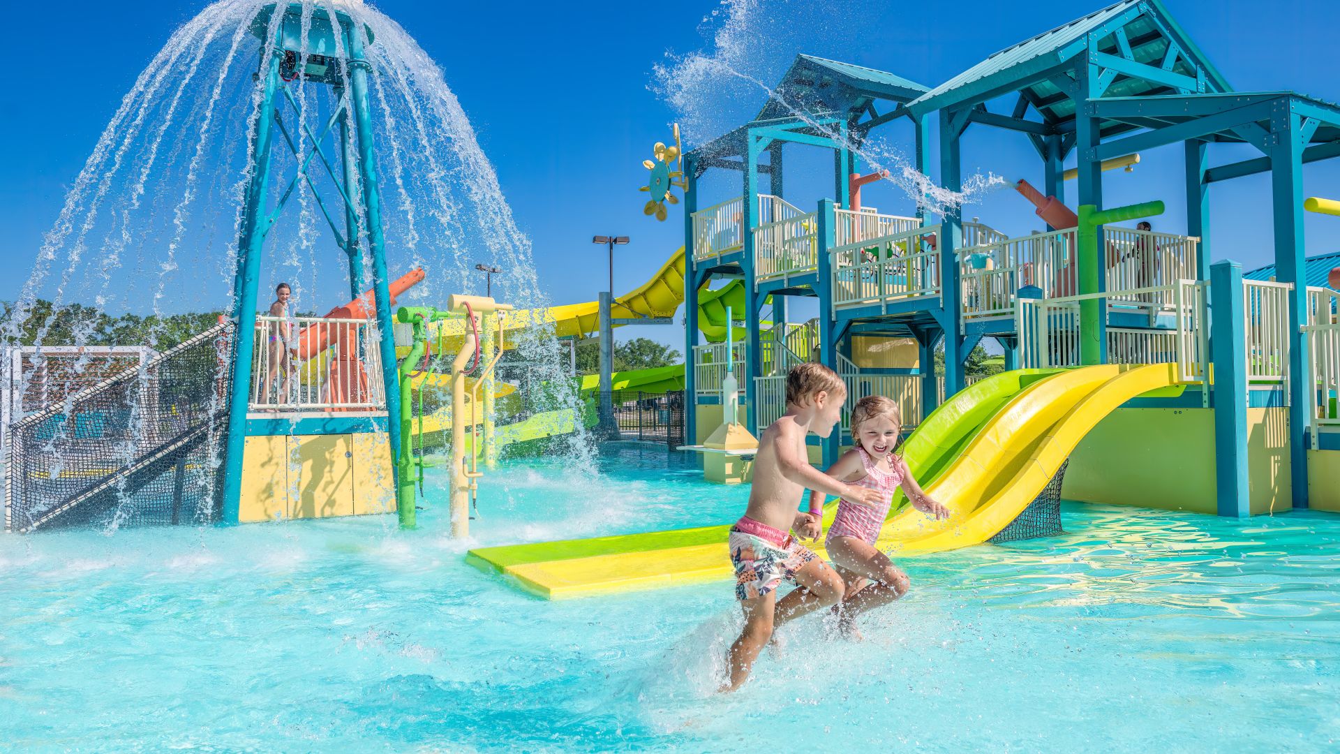 A Couple Of Kids Playing In A Water Park
