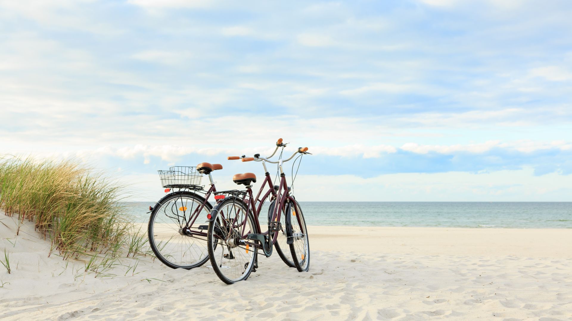 A Group Of Bikes Parked On A Beach