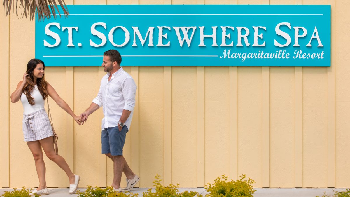 Couple holding hands outside St. Somewhere Spa at Margaritaville Resort Orlando.