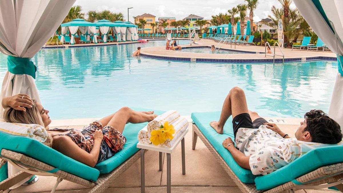 Young couple lounging in a poolside cabana at Margaritaville Resort Orlando.