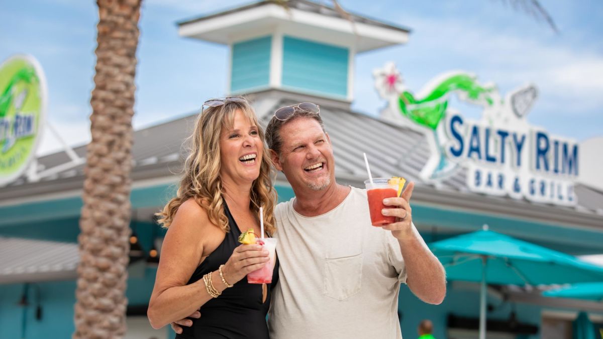 Couple with frozen drinks outside Salty Rim Bar and Grill.