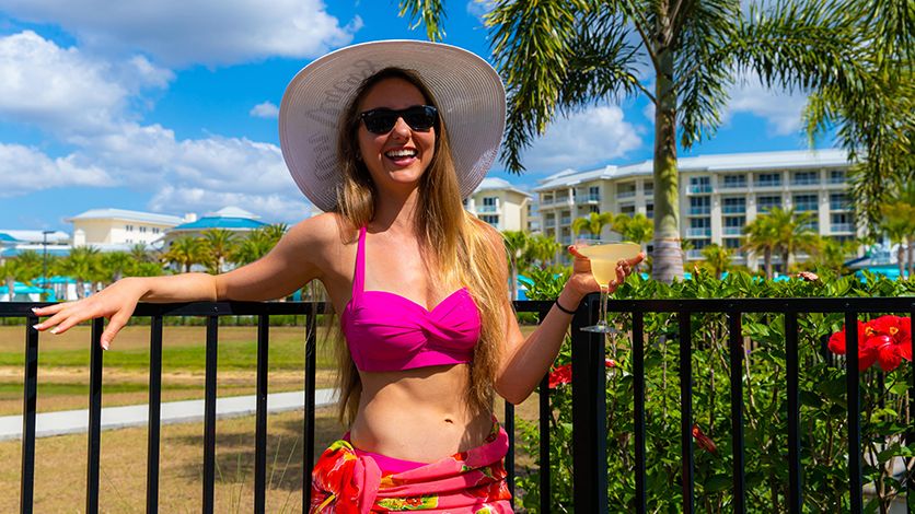 A woman in a bathing suit enjoying a margarita outside Margaritaville Resort Orlando