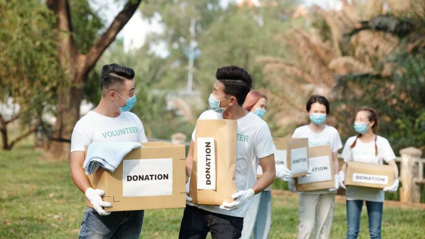 Group of volunteers carrying boxes at a charity event