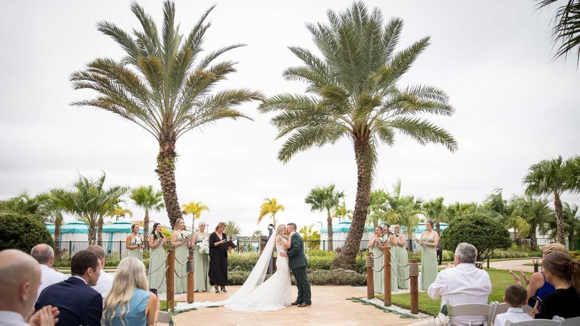 Outdoor wedding ceremony in front of beautiful palm trees at the Margaritaville Resort Orlando