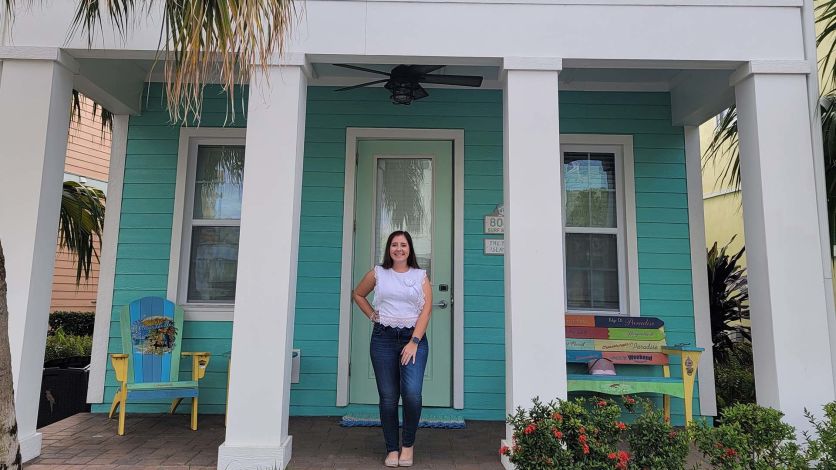 Guest standing on the porch of her Margaritaville Resort Orlando cottage home