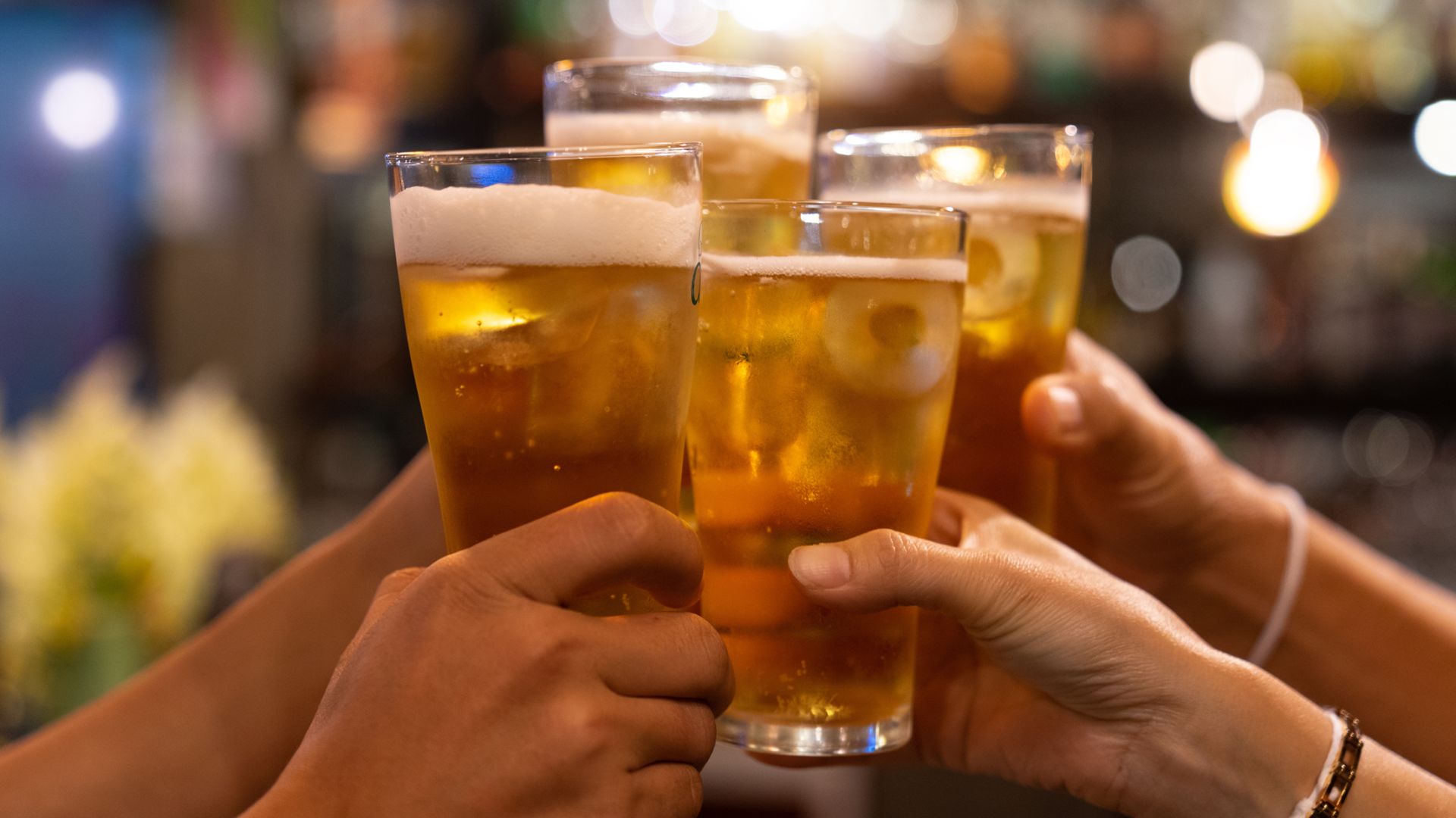 A Group Of Hands Holding Glasses Of Beer