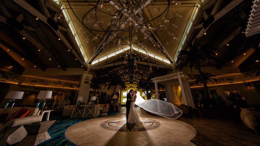 Bride and groom kiss in the Margaritaville Resort Orlando lobby