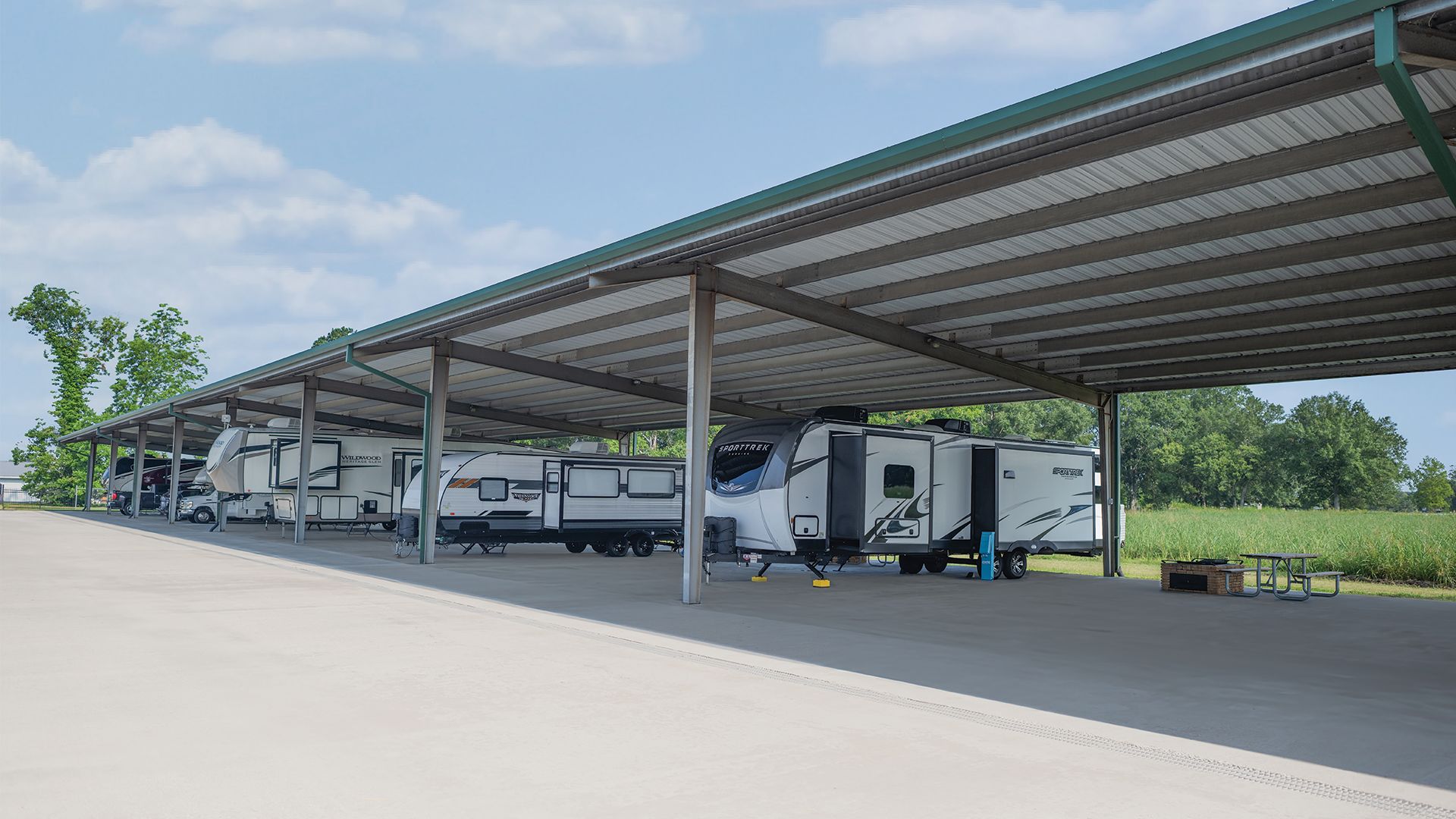A Group Of Rvs Parked Under A Covered Area