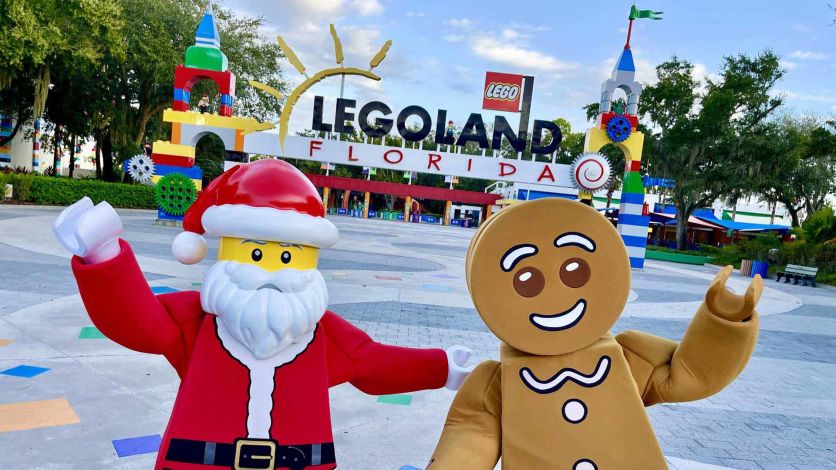 LEGO Santa and Gingerbread Man characters in front of the LEGOLAND Florida park entrance