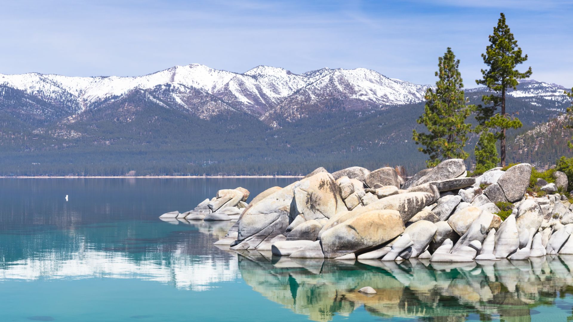 A Body Of Water With A Rocky Shoreline And A Mountain In The Background