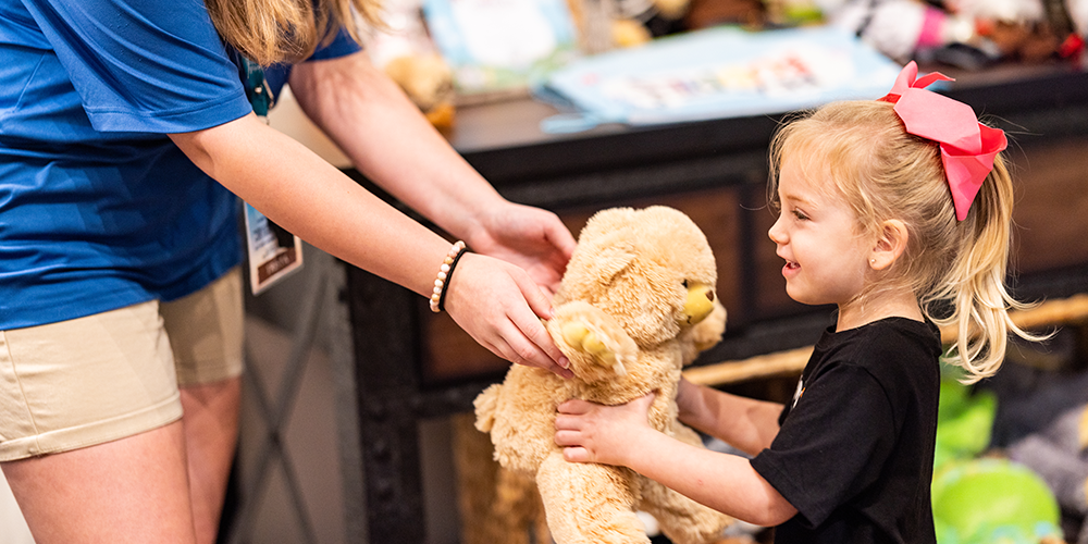 A Little Girl Holds A Teddy Bear