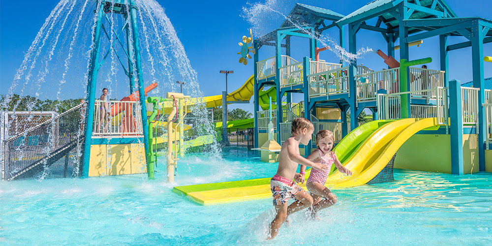 A Couple Of Kids Playing In A Water Park
